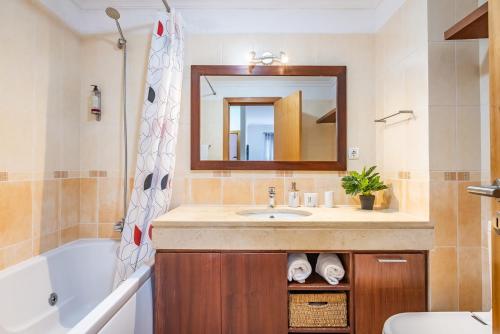 a bathroom with a sink and a tub and a mirror at Home to Stay by Homie in Funchal