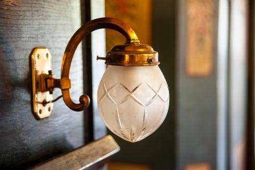 a light attached to a wall with a lamp on it at Penzion Na Stodolci in Chřibská