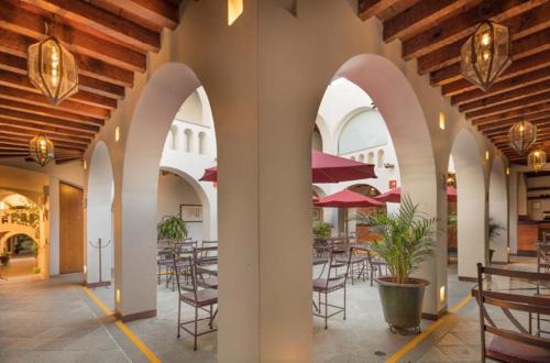 a patio with tables and chairs in a building at Hotel Casa Conzatti in Oaxaca City