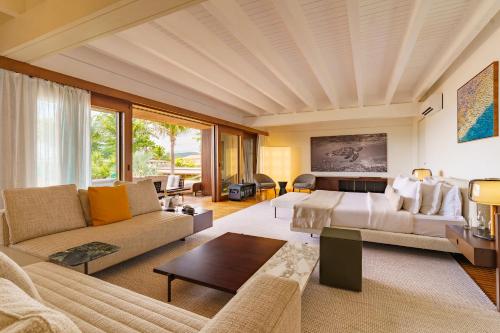 a bedroom with a bed and a living room at Zendaya Resort Beach Sport & Spa in Búzios