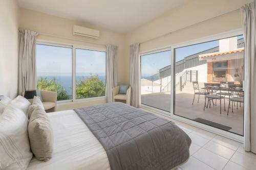 a bedroom with a bed and a view of the ocean at OurMadeira - Villa Aquarela, panoramic seaviews in Caniço