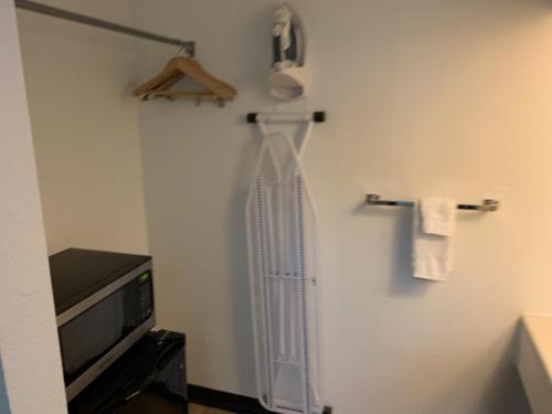 a bathroom with a towel rack and a tv at King's Inn in Torrington