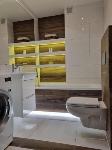 ein Badezimmer mit einem WC und einer Waschmaschine in der Unterkunft Apartament na obrzeżach Kalisza in Kościelna Wieś
