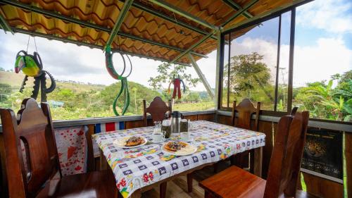 uma mesa e cadeiras num quarto com vista em Casita Rivera Río Celeste em Bijagua