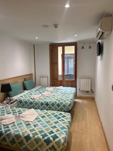 a room with two beds and a window at Hostal Restaurante in Pamplona