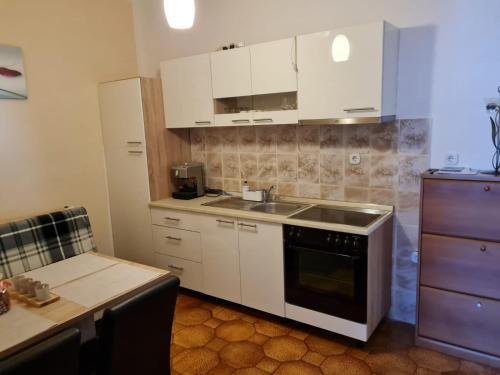 una cocina con armarios blancos y fregadero en Apartments Ljubic, en Tar