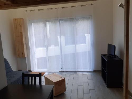 a living room with a large window and a tv at Logement entier: Un air d' évasion à Saint Pardon in Vayres