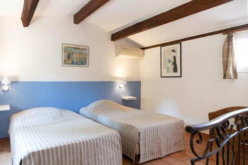 2 łóżka w pokoju z niebieskimi ścianami w obiekcie Les Gites du Merle w mieście Cogolin
