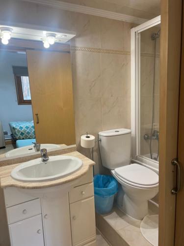 een badkamer met een wastafel, een toilet en een spiegel bij Hostal Restaurante in Pamplona
