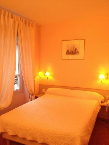 Ένα ή περισσότερα κρεβάτια σε δωμάτιο στο HÔTEL DES 3 MARCHES- Logis Hôtel Restaurant