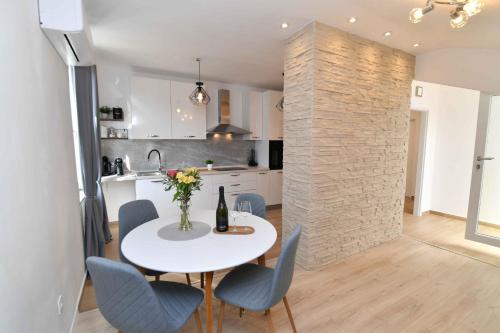 cocina y comedor con mesa blanca y sillas en Apartman Leona, en Lovran