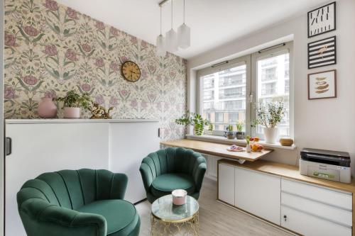a kitchen with two green chairs and a table at City Flower Apartment in Warsaw