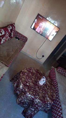 Habitación con TV de pantalla plana en la pared en اقامة الحديقة الضحى عمارة 54 العيايدة سلت en Sale