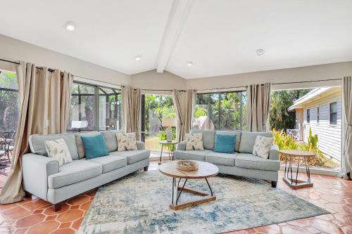 a living room with two couches and a table at Subtropical Oasis -Naples Fl Retreat in Naples