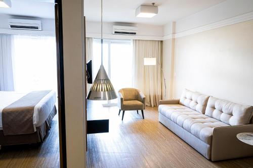 a hotel room with a couch and a bed at Manhattan Plaza in Brasilia