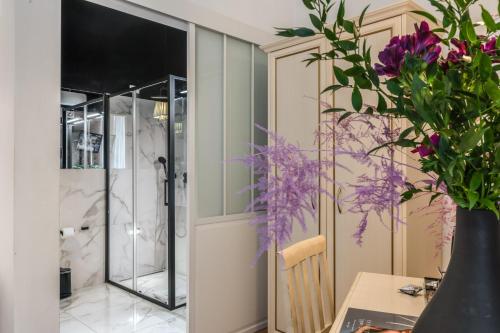 Cette chambre comprend une table et un vase avec des fleurs violettes. dans l'établissement Baboon Room, à Rome
