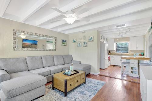 a living room with a couch and a table at Sunny Naples - Subtropical Oasis Cottage in Naples