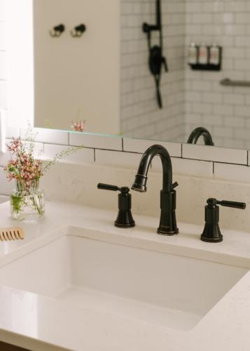 a kitchen sink with two faucets and a mirror at FOUND Hotel, Santa Monica in Los Angeles