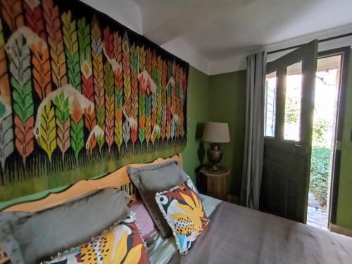 1 dormitorio con una pintura en la pared en La Fontaine, en Bargème