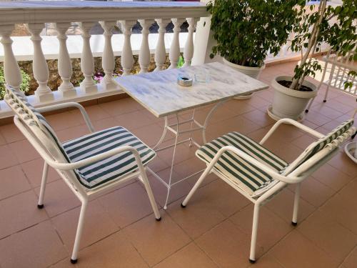 two chairs and a table on a balcony at Olga's Place in Spetses