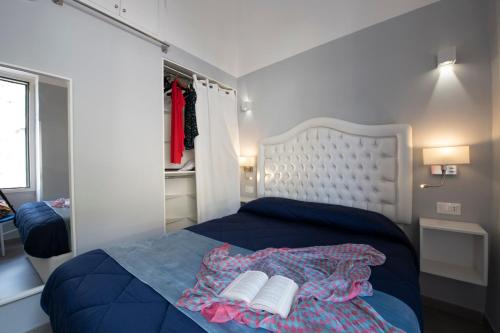um quarto com uma cama azul com dois livros em Vittoria House Centro Storico em Amalfi