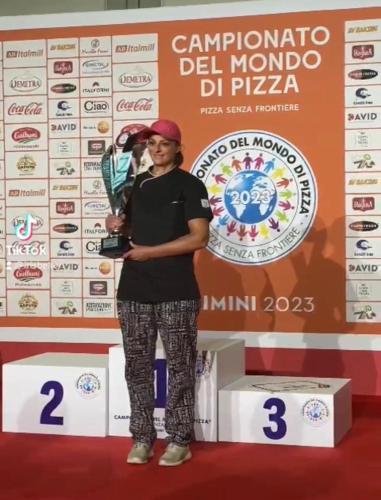 a man standing on a podium holding a trophy at Ostello Trentapassi in Zone