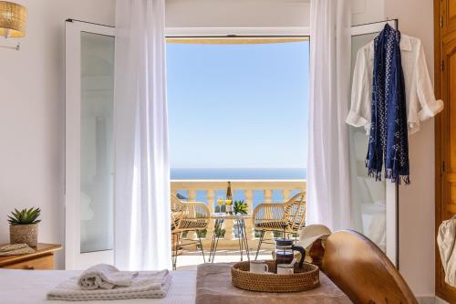 a bedroom with a bed and a view of the ocean at Casa Thalassa in Balcon del Mar