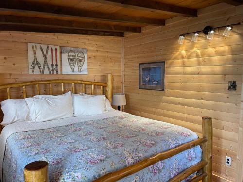 um quarto com uma cama num chalé de madeira em The Outback On The Creek With High Speed Wifi em Red River