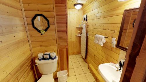uma casa de banho em madeira com um WC e um lavatório em The Outback On The Creek With High Speed Wifi em Red River