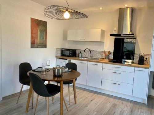 une cuisine avec une table et des chaises dans une cuisine dans l'établissement Bienvenue à La Petite Virette, à Saint-Rémy-de-Provence