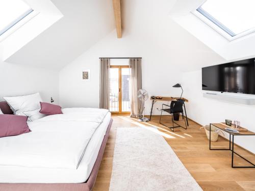 a white living room with a white couch and a tv at Alte Schule Tiefenbach in Tiefenbach