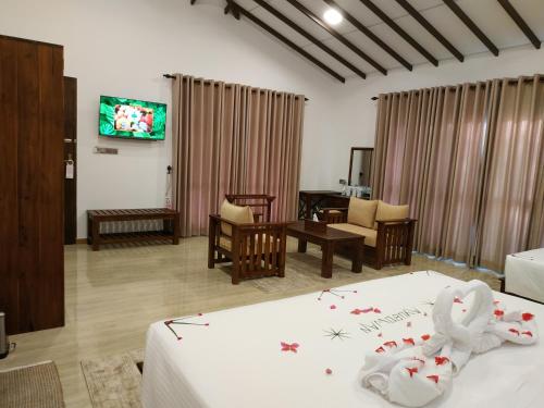 a hotel room with two beds and a tv at Sigiriya Cashew Palace Resort in Sigiriya