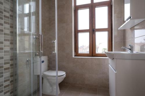 baño con aseo y lavabo y ventana en FENIX Gevgelija, en Gevgelija