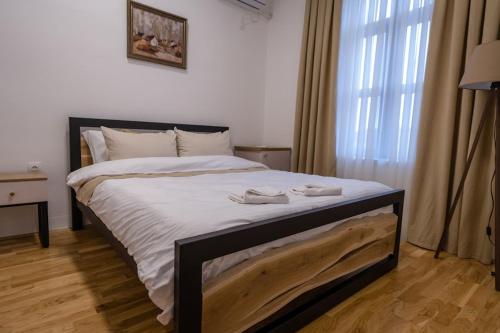 1 dormitorio con 1 cama grande con sábanas blancas en FENIX Gevgelija, en Gevgelija