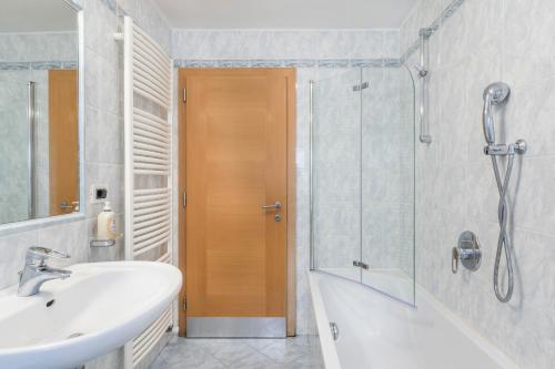 uma casa de banho com um lavatório, um chuveiro e uma banheira em Manuela em Ortisei