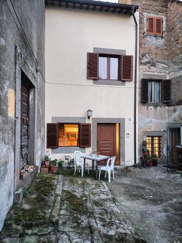 a house with a table and chairs in a courtyard at Il palazzetto "fori porta" in Vitorchiano