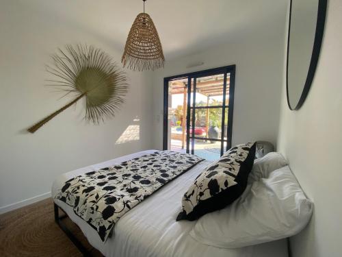 a bedroom with a bed with black and white pillows at Villa Meli - Le Porge : la plage, Lège-Cap Ferret et Lacanau à 10 minutes in Le Porge