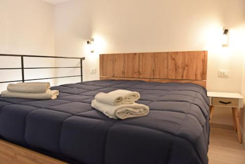 a bedroom with a blue bed with towels on it at La Corte di Vincenzo in Noto
