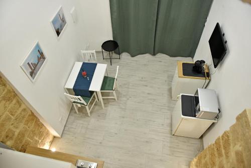 ein Wohnzimmer mit einem Tisch und einem TV in der Unterkunft La Corte di Vincenzo in Noto