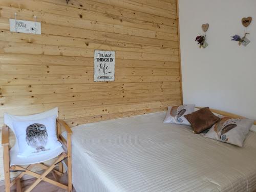 1 dormitorio con 1 cama, 1 silla y 1 cartel en Cabana Praid, en Praid