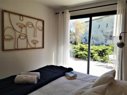 a bedroom with a bed and a large window at Bienvenue à La Petite Virette in Saint-Rémy-de-Provence