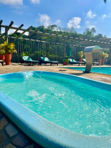 a swimming pool with blue water in a yard at Hotel Bertell in Penedo