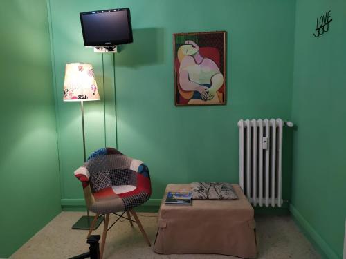 a living room with a chair and a tv at roma capoccia b&b in Rome