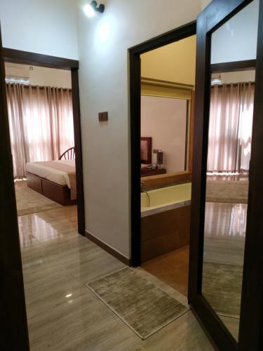 a room with a mirror and a bed and a tub at Sigiriya Cashew Palace Resort in Sigiriya
