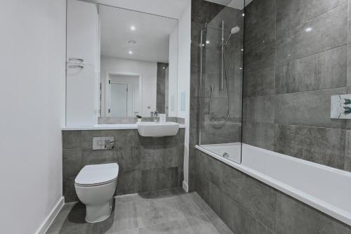 a bathroom with a toilet and a tub and a sink at Khayat Homes - The Curve - One Bed in London