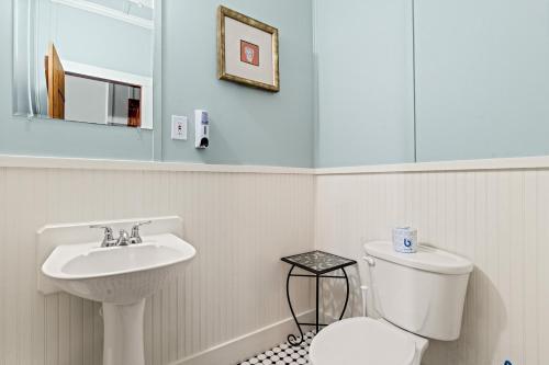 een badkamer met een wit toilet en een wastafel bij Nags Head Beach Inn by KEES Vacations in Nags Head