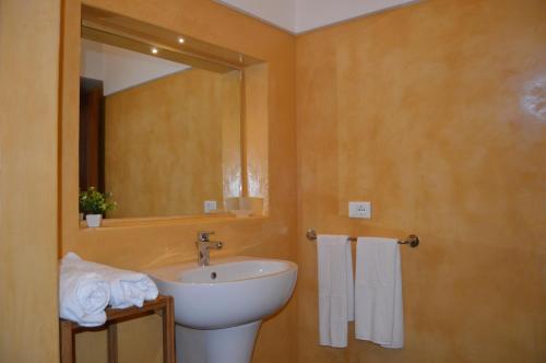 bagno con lavandino, specchio e asciugamani di I DAMMUSI DEL VENTO a Pantelleria