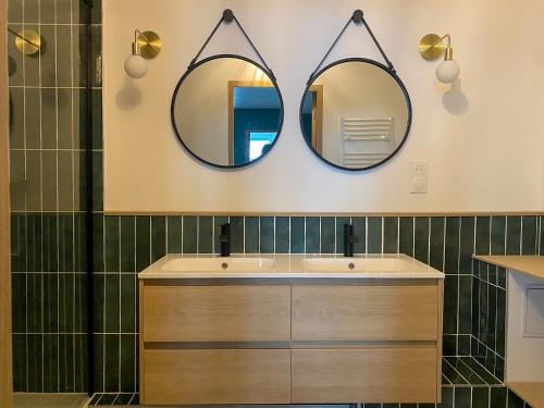 - une salle de bains avec deux miroirs au-dessus d'un lavabo dans l'établissement - La Jungle -, à Strasbourg