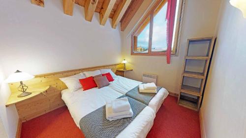 um quarto com uma cama, uma secretária e uma janela em Le Sabot de Vénus em Val Thorens