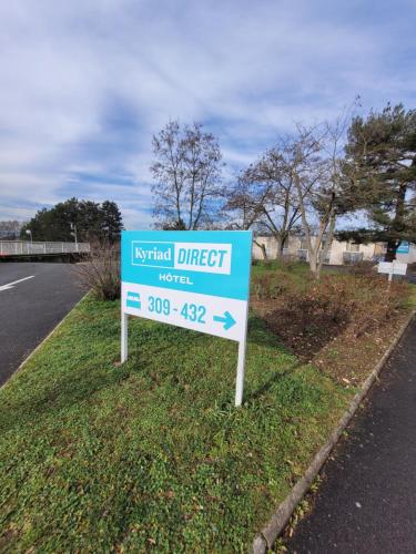 a sign in the grass next to a road at KYRIAD DIRECT LYON NORD - Dardilly in Dardilly